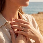 Gold ring with multicolored stones on finger