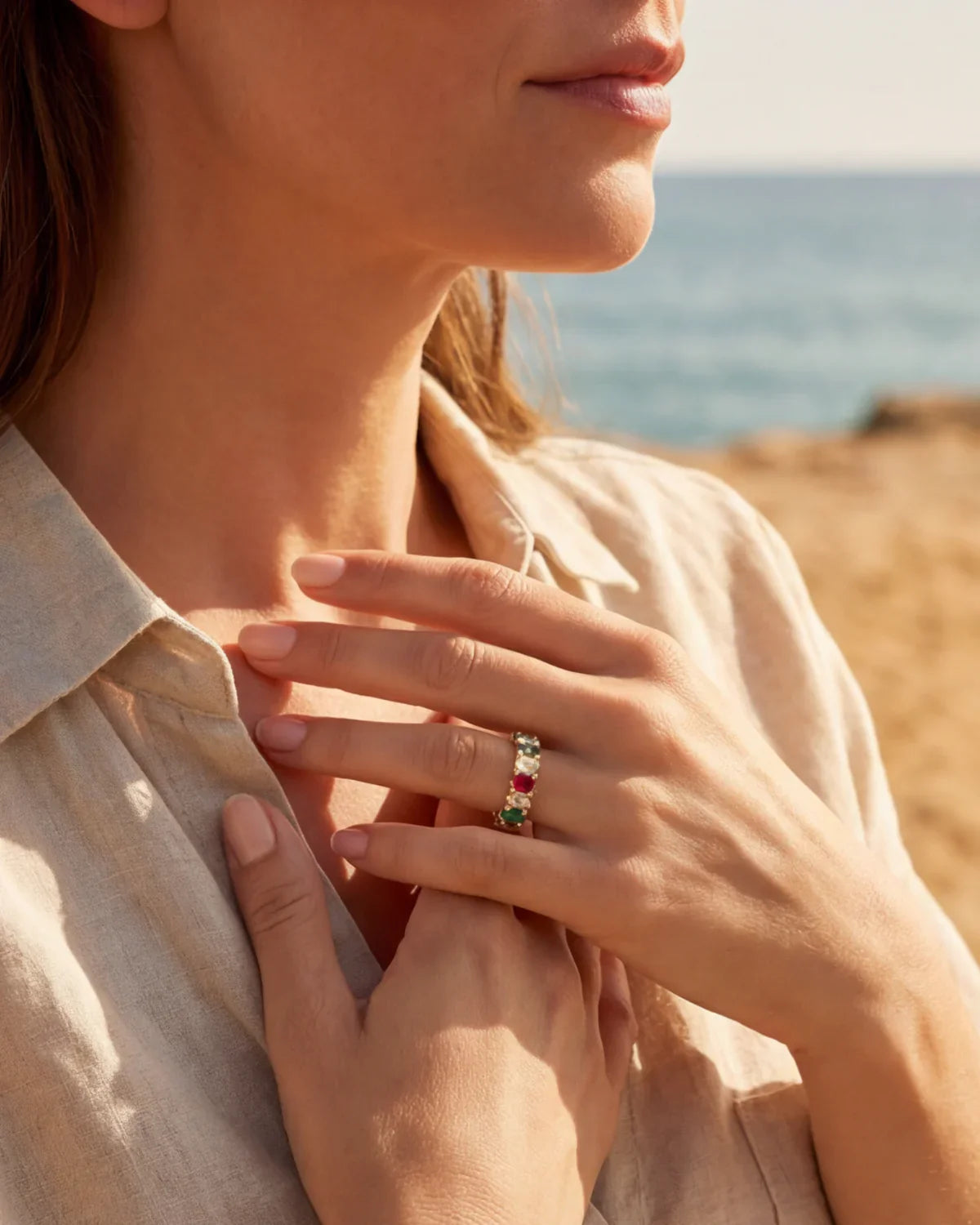 Gold ring with multicolored stones on finger