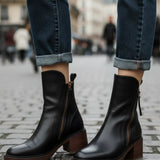Black leather ankle boots with side zipper and tassel, outdoor street view