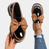 Beige heeled loafers with chunky sole and large tan bow detail