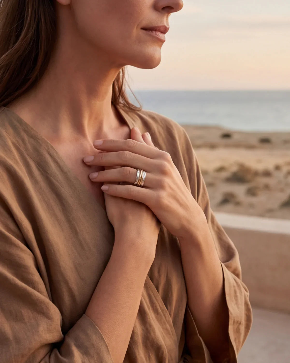 Three-band modern ring on finger, silver with gold-tone accents