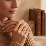 Gold ring with clear stone band, worn on a woman’s finger