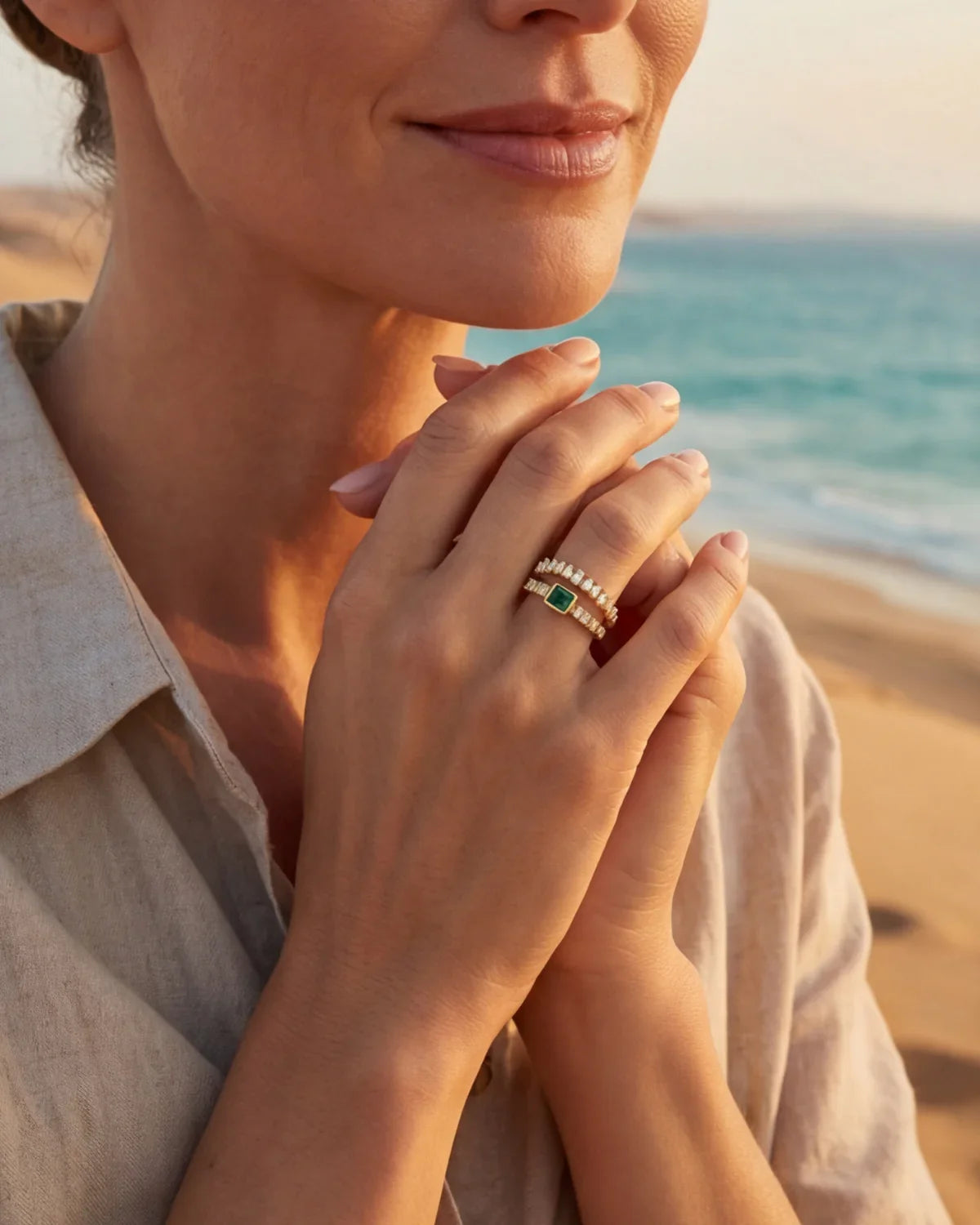 Gold ring with green stone and pavé band on hand