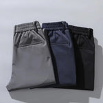 Pack of three men's dress pants: gray, navy, and black with elastic waist