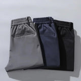 Pack of three men's dress pants: gray, navy, and black with elastic waist