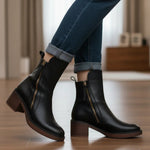 Black leather ankle boots with side zipper and tassel, block heel on floor