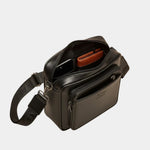 Black leather shoulder bag with open top showing orange lining and zip compartment
