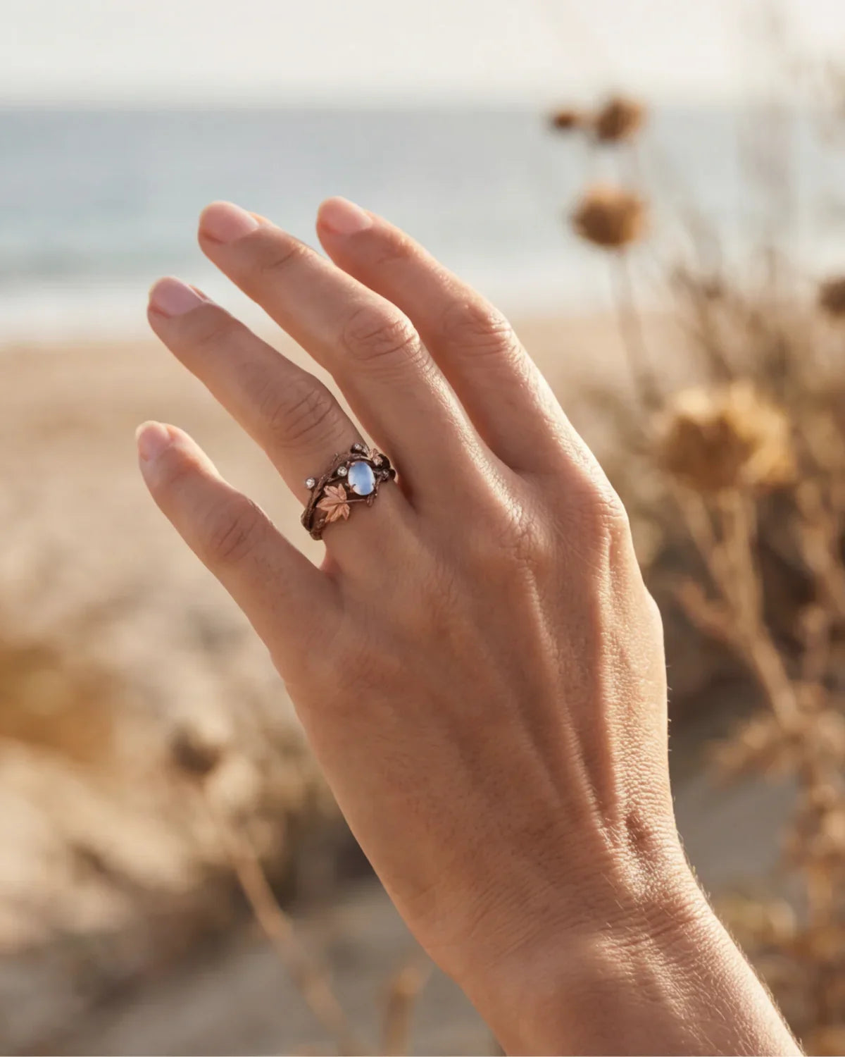 Bronze branch-effect ring with oval opalescent blue cabochon and leafy setting