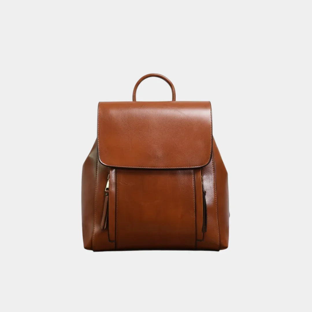 Caramel leather backpack with top flap, curved handle, and front zip pockets