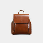 Caramel leather backpack with top flap, curved handle, and front zip pockets
