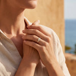 Gold ring with clear cluster stone on finger
