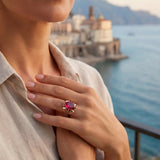 Livia sapphire ring on finger, gold setting with oval pink-magenta gemstone