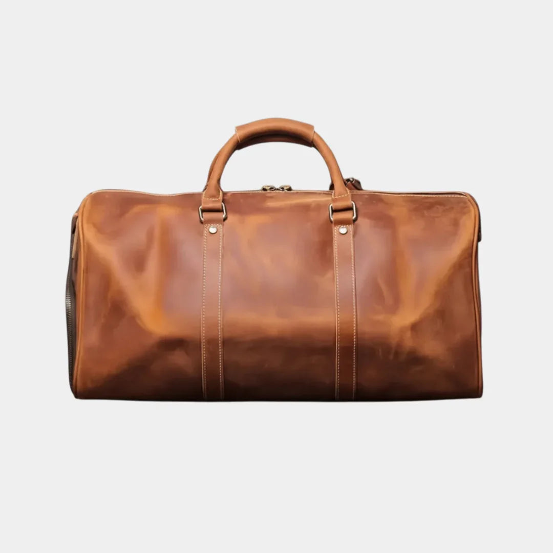 Caramel leather travel bag with top handle, front seams, and metal clasp