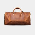 Caramel leather travel bag with top handle, front seams, and metal clasp