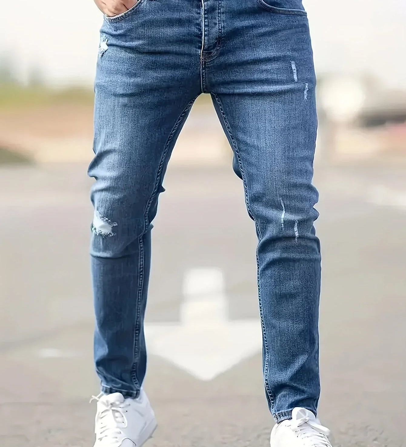 Slim-fit ripped jeans in light blue, distressed knee patches and top button