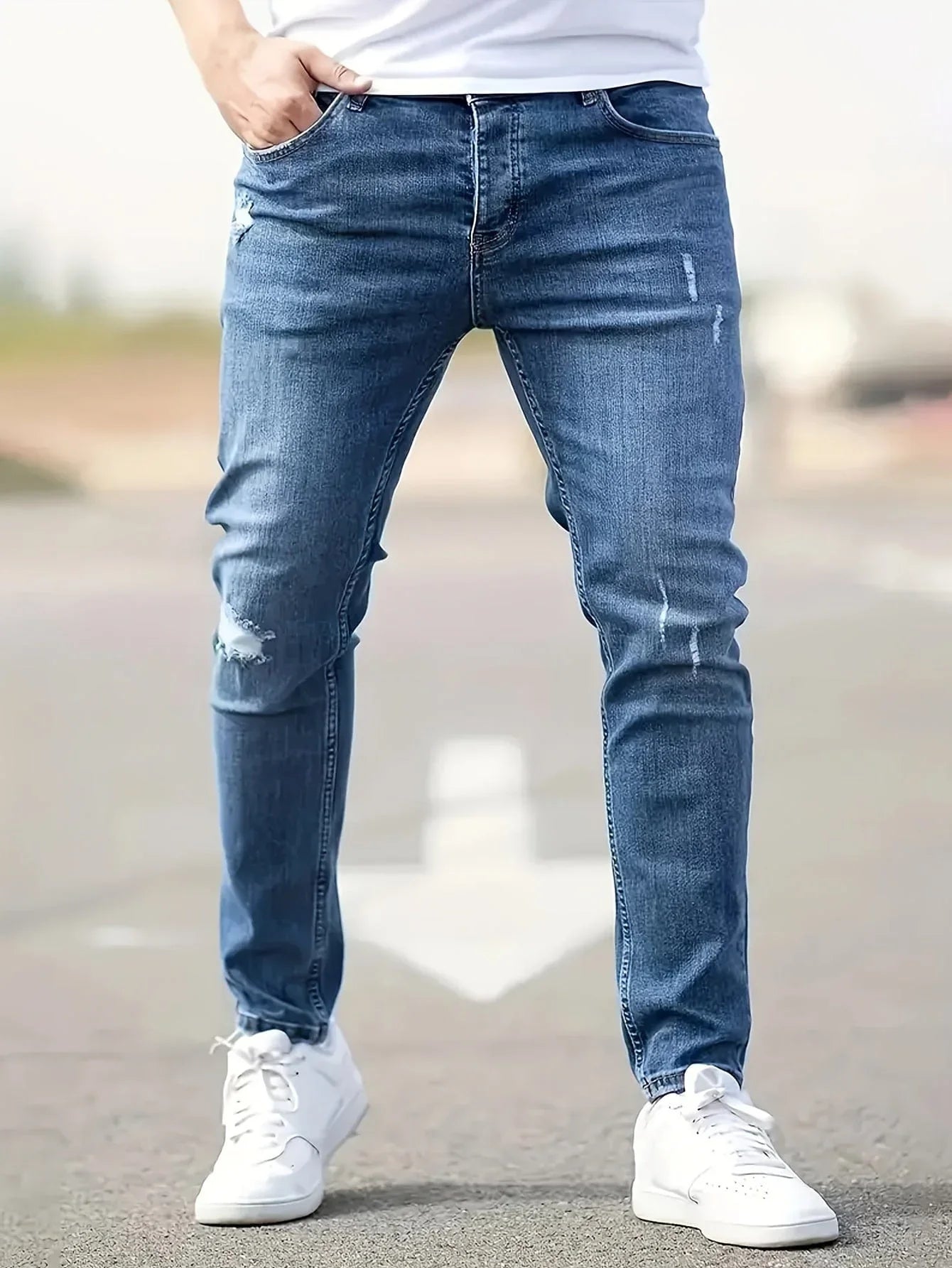 Slim-fit ripped jeans in light blue, distressed knee patches and top button
