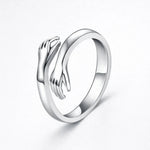 Silver embrace ring with open top and sculpted wave detail