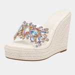 White heeled platform sandals with multicolor jeweled floral strap and woven wedge