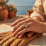 Gold-tone ring with a green square gemstone on the finger