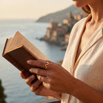 Gold wavy ring on finger holding a book