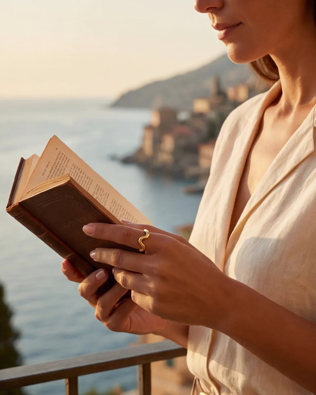 Gold wavy ring on finger holding a book