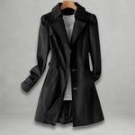 Black spring trench coat with double-breasted buttons, notched lapels, and flap pockets
