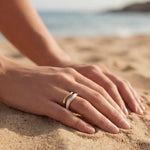 Adjustable gold ring with white inlay stripe, worn on finger