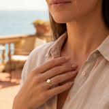 Gold-tone ring with white flower centerpiece and clear stone details