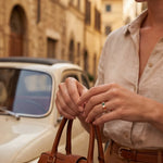 Gold ring with multicolored stones on finger