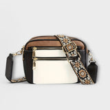 Two-tone small crossbody bag with white front panel and patterned fabric strap.