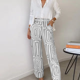 Two-piece outfit: white blouse with belt; wide-leg cream pants with gray abstract blocks