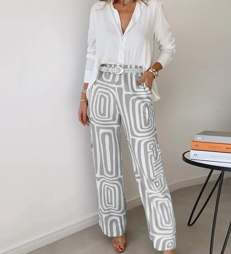 Two-piece outfit: white blouse with belt; wide-leg cream pants with gray abstract blocks