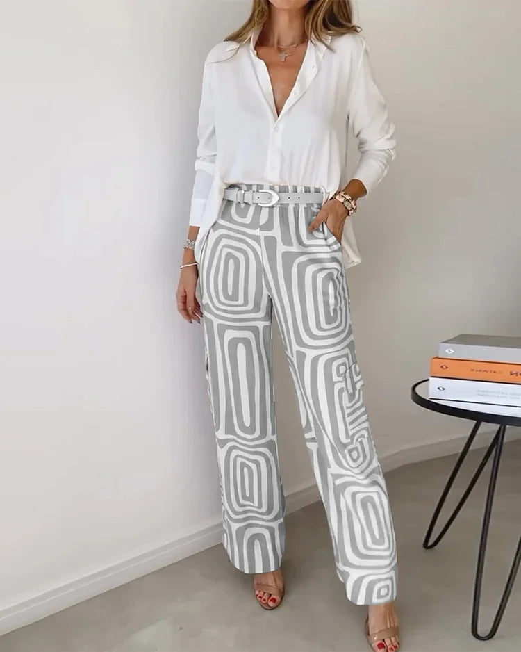 Two-piece outfit: white blouse with belt; wide-leg cream pants with gray abstract blocks