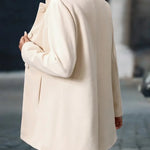 Cream button-front daily jacket with long sleeves and stand collar.