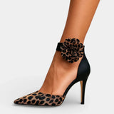 Leopard print high heels with black ankle strap and leopard rosette on the ankle.