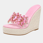 Pink heeled platform sandals with jeweled floral strap and woven jute wedge