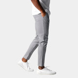 Light gray chino pants with button closure, front pockets, and tapered fit.