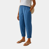 Blue linen-effect pants with elastic waist, button detail, and cuffed ankle hems