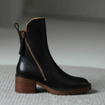 Black leather ankle boots with side zipper, brown heel and sole edge
