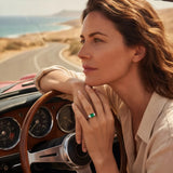 Green square gemstone ring on a hand with a gold-tone band