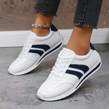 White lightweight orthopedic sneakers with navy stripe accents, lace-up design
