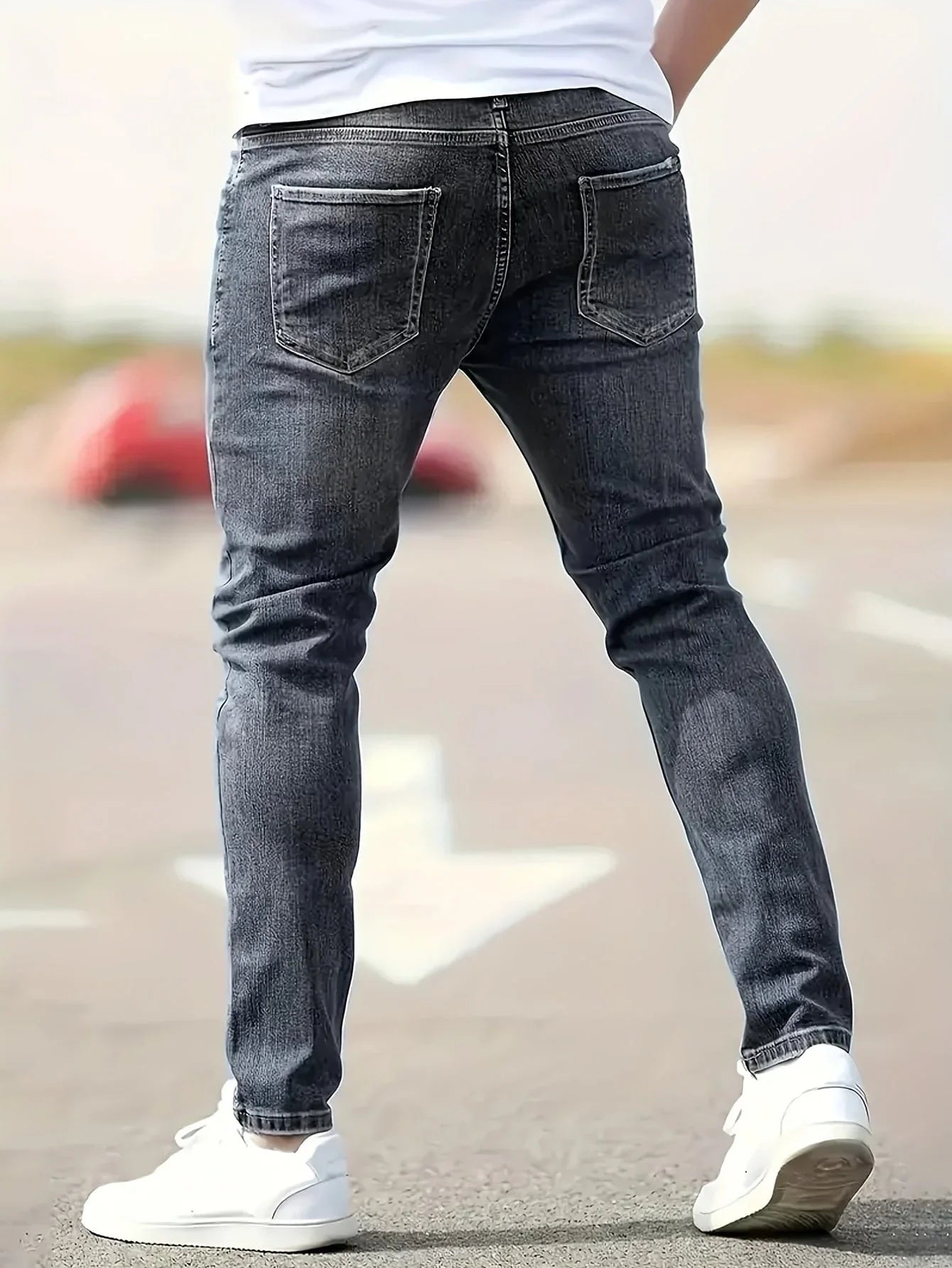 Dark gray ripped slim-fit jeans with five-pocket denim and distressed knee rips
