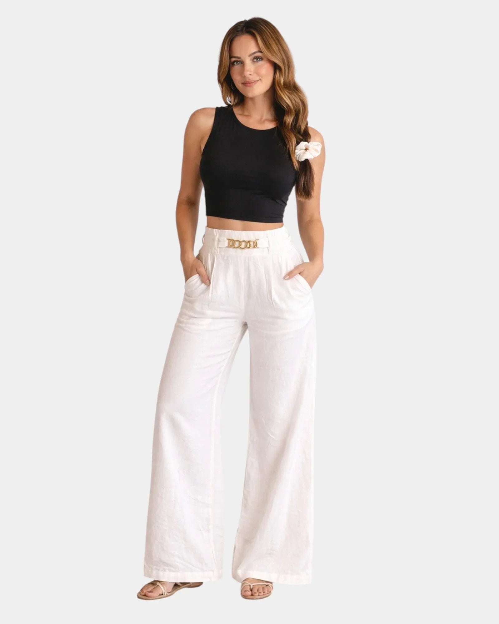 White high-waist wide-leg pants with gold chain belt detail