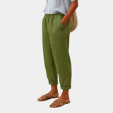 Green linen-effect pants with elastic waist, button detail, and cuffed ankle hems