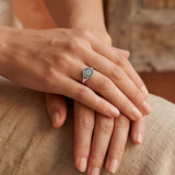 Silver-tone ring with a round engraved sunburst medallion on a slim band