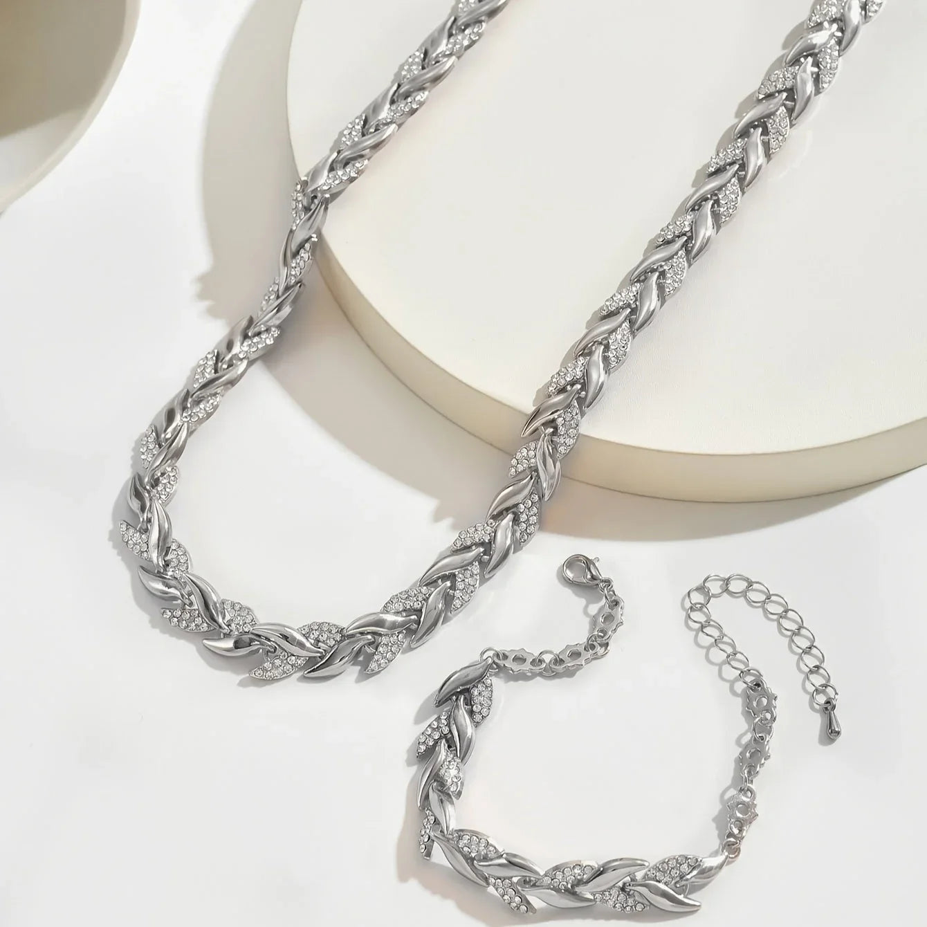 Silver fish tail link necklace set with matching bracelet pieces on display