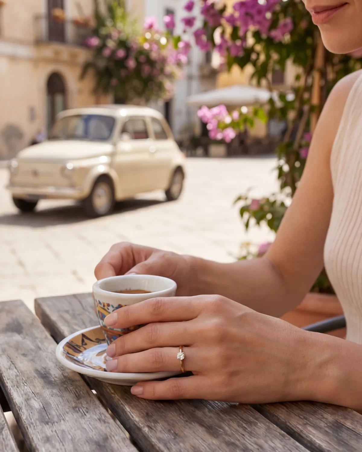 Solitaire ring with small round gemstone on hand holding a cup