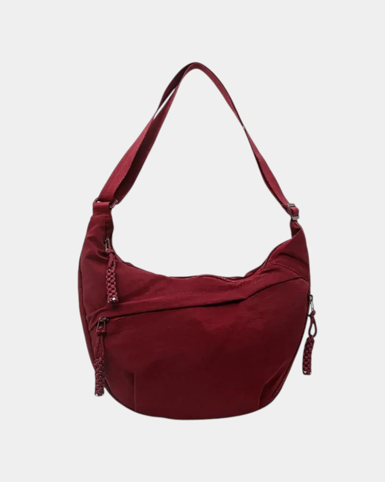 Burgundy anti-theft crossbody bag with curved hobo shape, adjustable strap, and zipper pull.