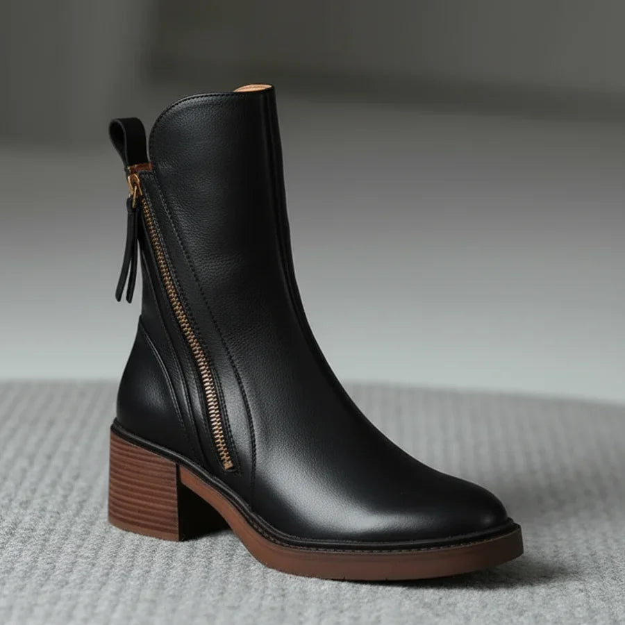 Black leather ankle boots with side zipper and tassel, close-up side view