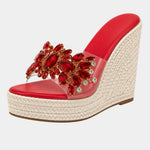 Red heeled platform sandals with red jeweled floral strap and woven wedge